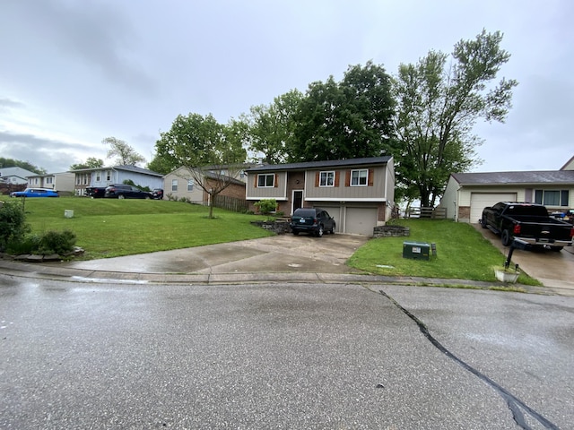 bi-level home with driveway, a front lawn, a garage, and a residential view