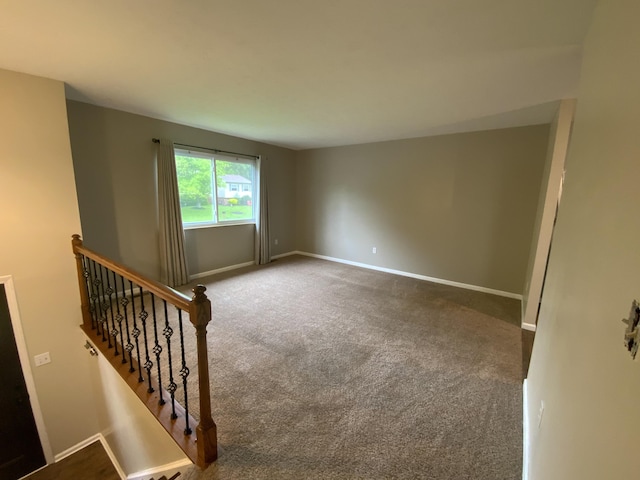 unfurnished room featuring carpet and baseboards