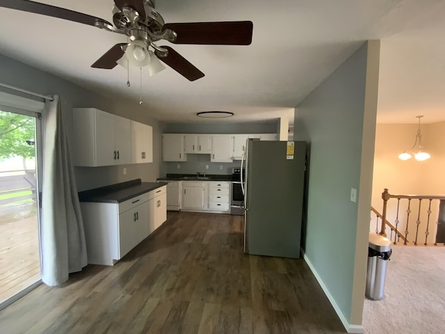 kitchen with freestanding refrigerator, dark countertops, dishwasher, white cabinets, and ceiling fan