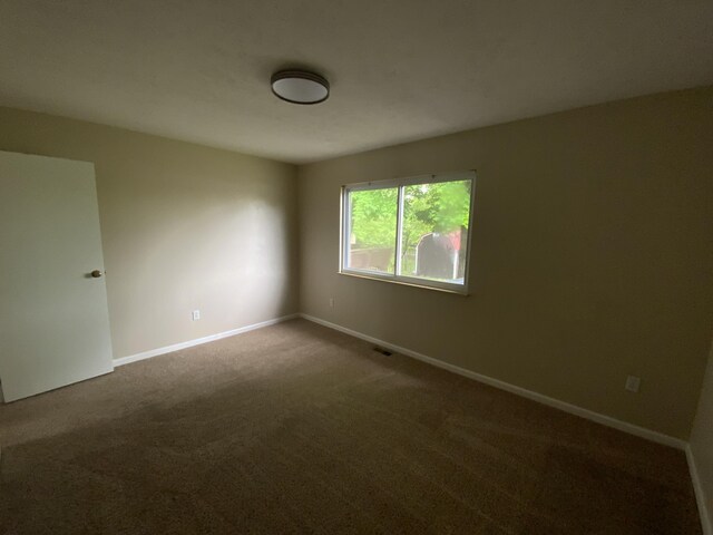 carpeted empty room with baseboards