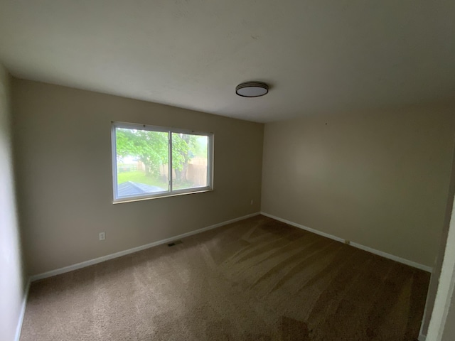 carpeted spare room with baseboards