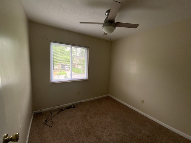 empty room featuring carpet floors, a ceiling fan, and baseboards
