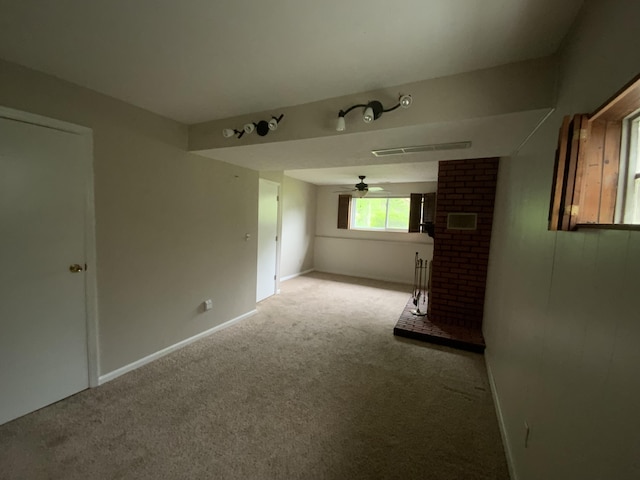 unfurnished living room featuring carpet, a ceiling fan, a fireplace, and baseboards