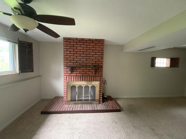 unfurnished living room with ceiling fan, carpet flooring, a brick fireplace, and baseboards