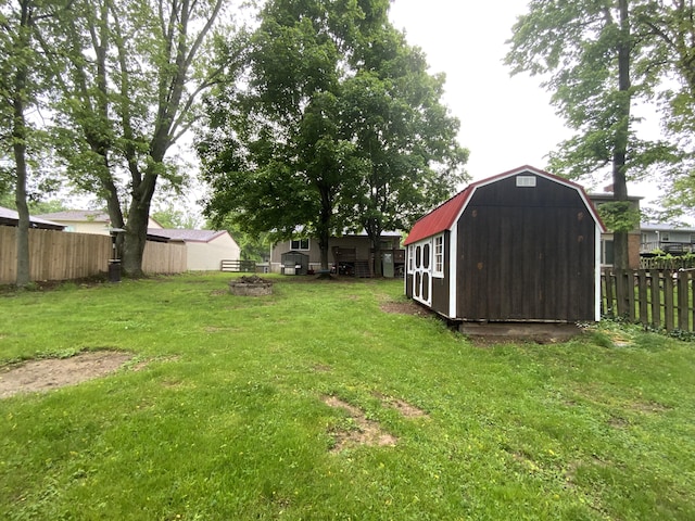 view of yard with an outdoor structure, a storage shed, and a fire pit