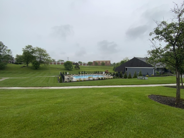 surrounding community with a lawn and a swimming pool