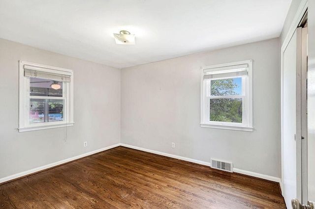unfurnished bedroom featuring baseboards, wood finished floors, and a closet
