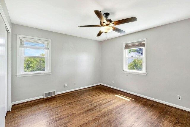 spare room with wood finished floors, baseboards, and a ceiling fan