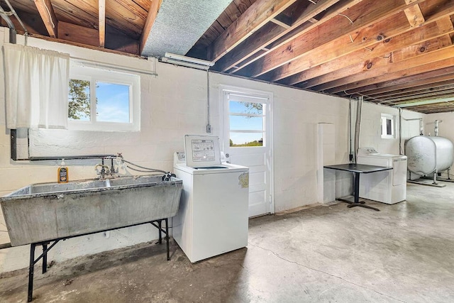 washroom with heating fuel, washing machine and dryer, healthy amount of natural light, and concrete block wall