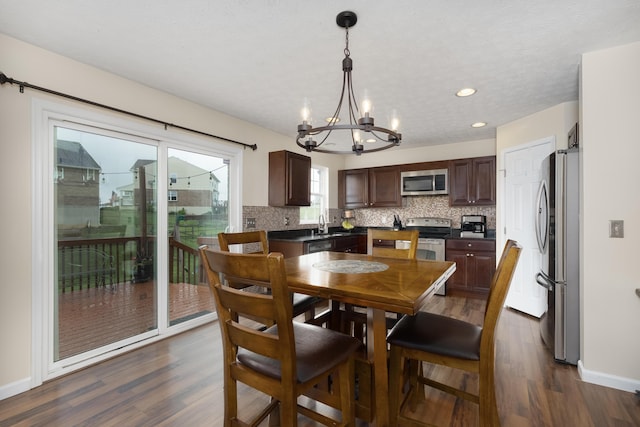 dining room with a chandelier, dark wood-style flooring, baseboards, and recessed lighting