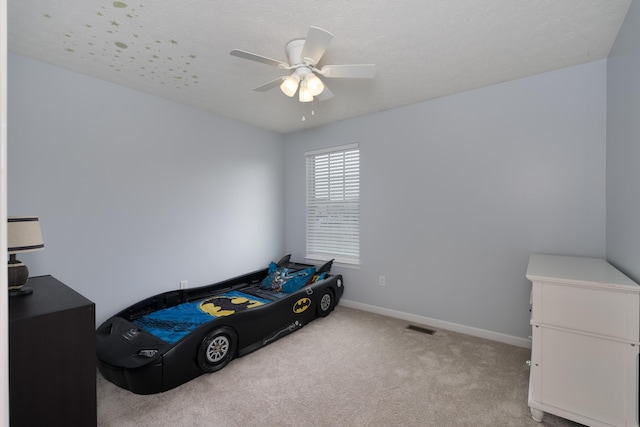 carpeted bedroom featuring baseboards and a ceiling fan
