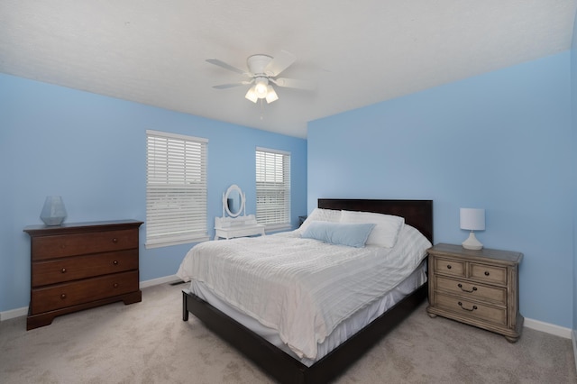 bedroom with light colored carpet, baseboards, and ceiling fan