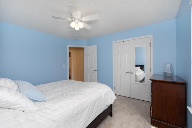 bedroom with light colored carpet, ceiling fan, and a closet