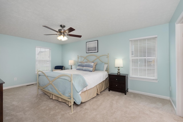 bedroom featuring baseboards, light colored carpet, and ceiling fan
