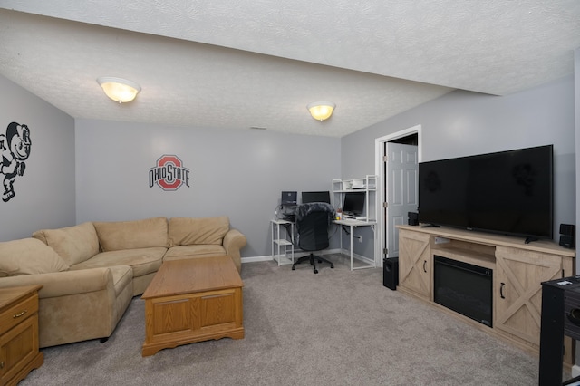 living area featuring light carpet, an office area, baseboards, and a textured ceiling