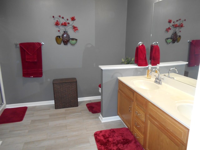 bathroom with baseboards and double vanity