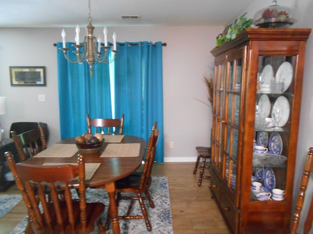 dining space with a chandelier and wood finished floors