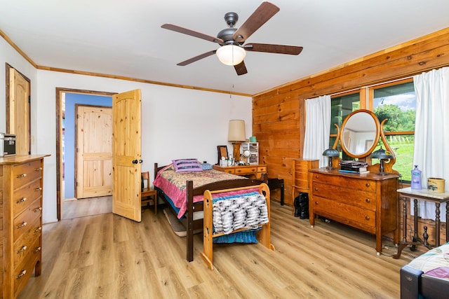 bedroom featuring light wood-style floors, crown molding, and wood walls