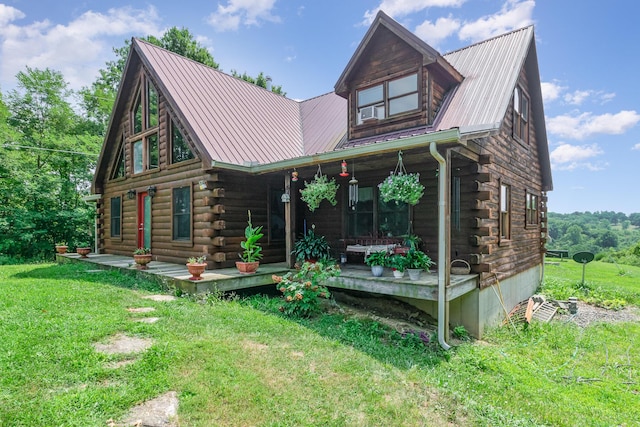view of front of property with log siding, a porch, a front yard, and metal roof