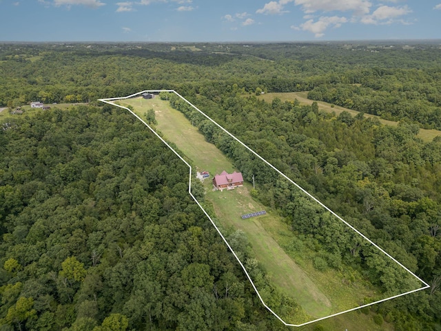 aerial overview of property's location with a heavily wooded area and property boundaries highlighted