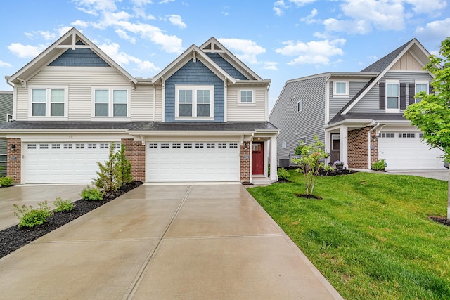 craftsman-style home featuring a front yard, an attached garage, brick siding, and driveway