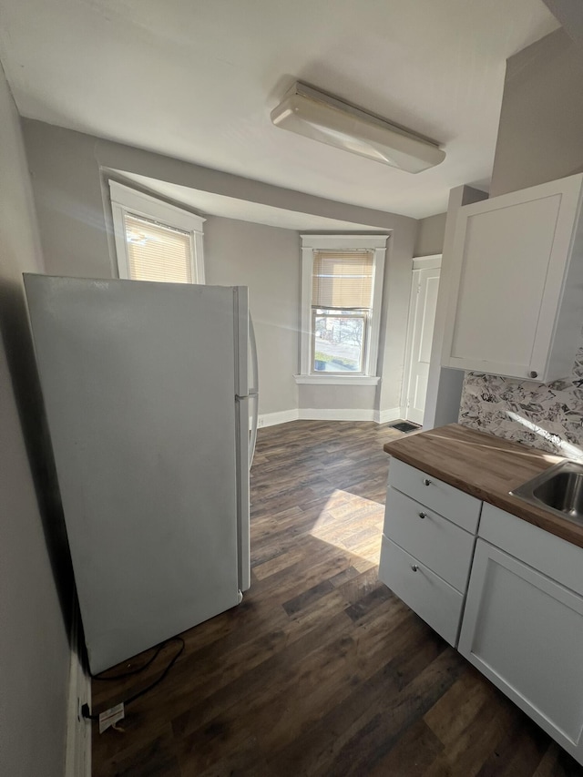 417 W 19th St, Covington, KY 41014 - kitchen with freestanding refrigerator, butcher block countertops, dark wood-style floors, and white cabinetry