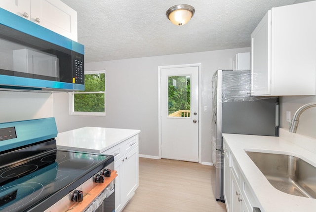 3492 Ridgewood Dr, Erlanger, KY 41018 - kitchen with appliances with stainless steel finishes, a sink, white cabinetry, light countertops, and a textured ceiling