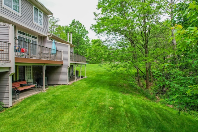 view of grassy yard with a wooden deck and central AC unit
