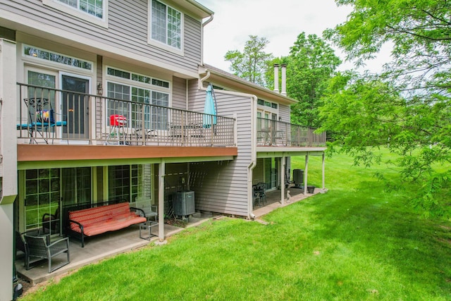 back of property with a lawn, a patio, and central AC