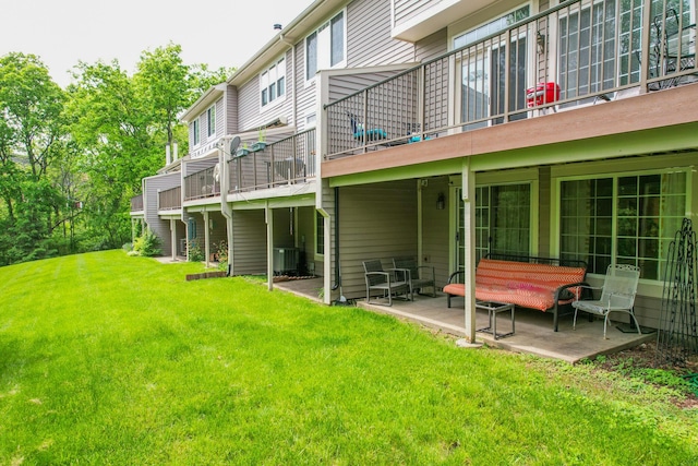 rear view of property featuring a yard, central air condition unit, and a patio area
