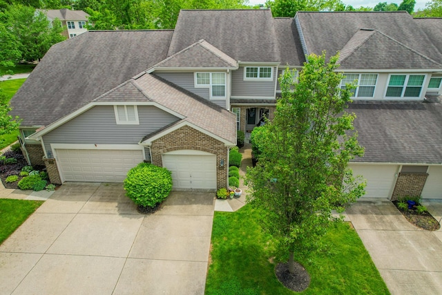 view of front of house featuring brick siding, concrete driveway, a garage, and a shingled roof