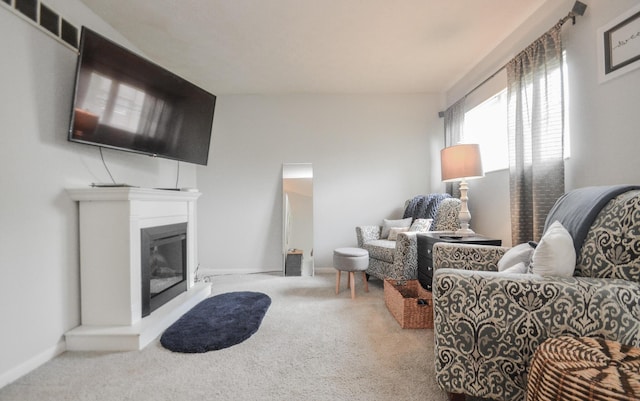 living room with carpet flooring, a glass covered fireplace, and baseboards