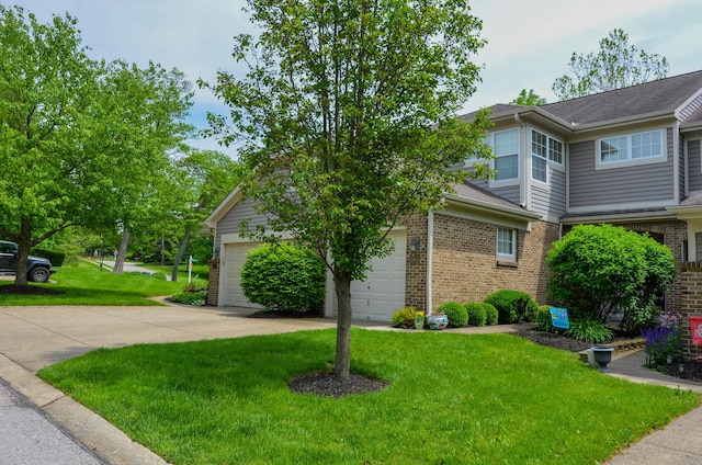 view of front facade with brick siding, a front lawn, concrete driveway, an attached garage, and roof with shingles