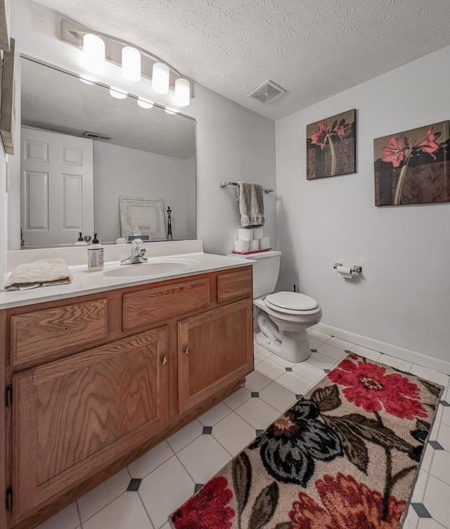 bathroom with toilet, vanity, and a textured ceiling
