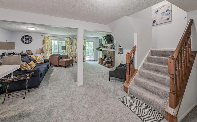 living area with carpet floors, stairway, a textured ceiling, and a glass covered fireplace