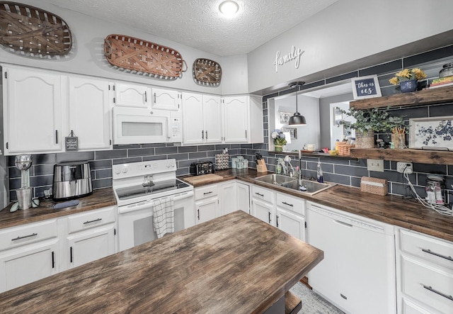 kitchen featuring wood counters, white appliances, a sink, tasteful backsplash, and a textured ceiling