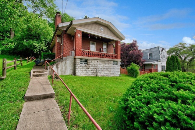 view of front of home featuring a chimney, brick siding, and a porch