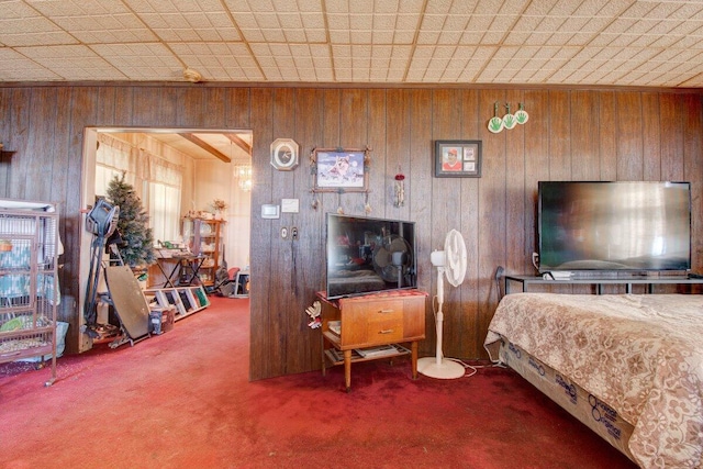 carpeted bedroom featuring wooden walls