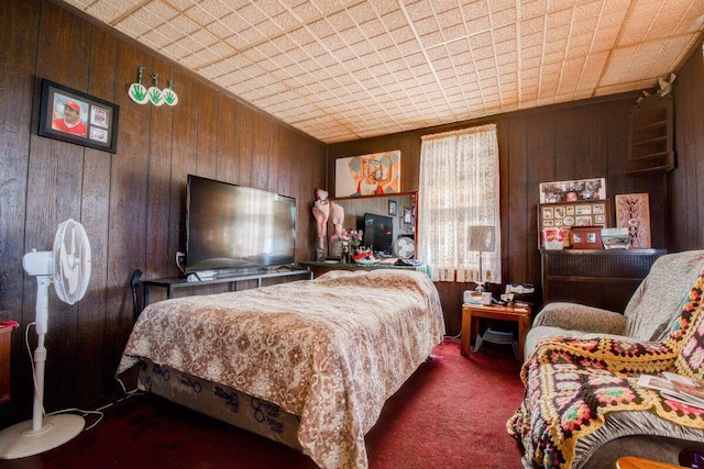 carpeted bedroom featuring wooden walls