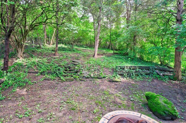 view of yard featuring a forest view and a fire pit