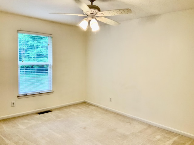 unfurnished room with light carpet, healthy amount of natural light, and baseboards