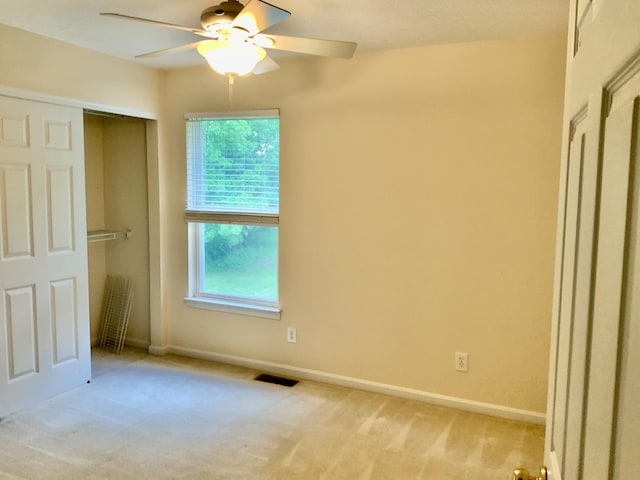 unfurnished bedroom with light colored carpet, multiple windows, and baseboards