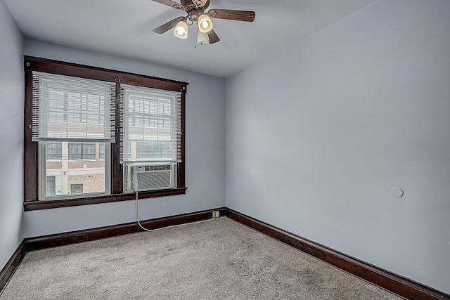 carpeted empty room featuring baseboards, ceiling fan, and cooling unit
