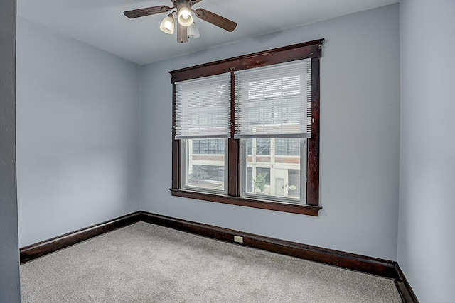 carpeted spare room with baseboards and ceiling fan