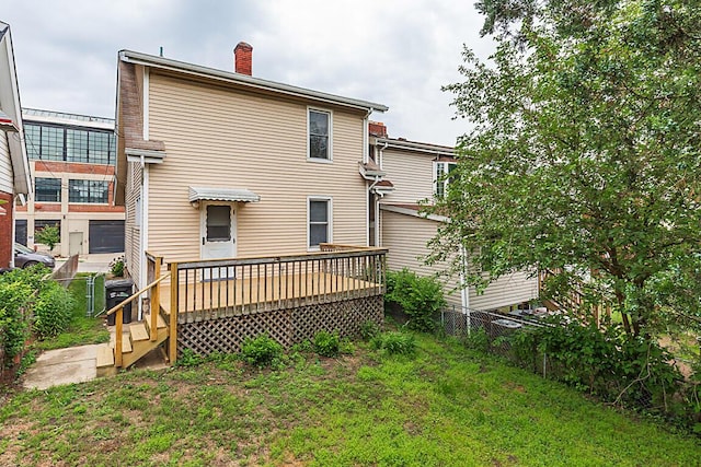 back of house with a wooden deck and a chimney