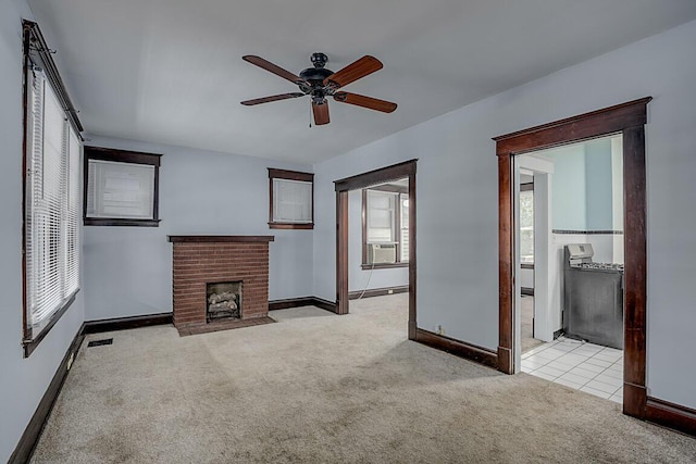 unfurnished living room featuring carpet flooring, a ceiling fan, baseboards, a fireplace, and cooling unit