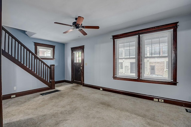 entryway with carpet floors, stairs, baseboards, and a ceiling fan
