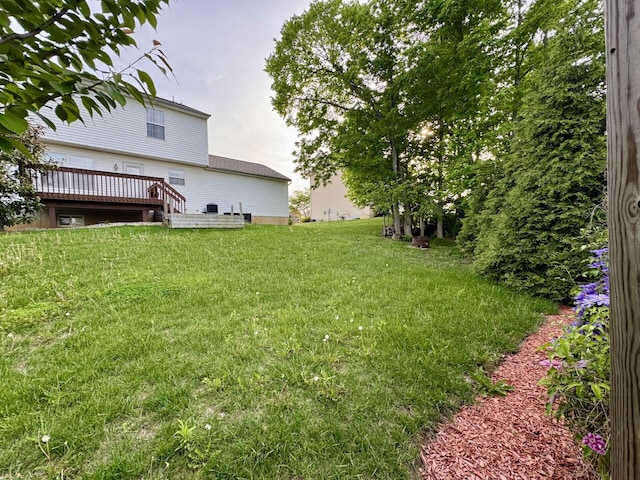 view of green lawn featuring a deck