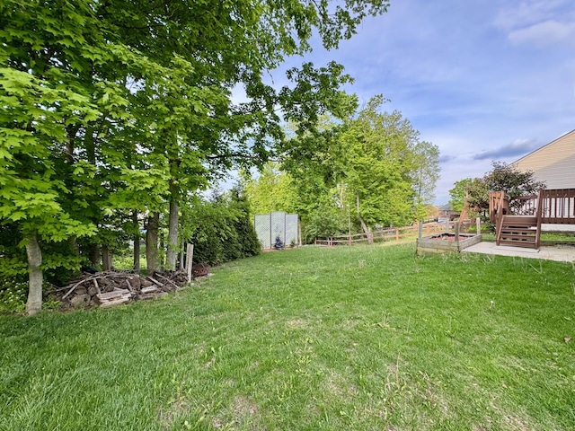 view of yard with a wooden deck and a vegetable garden