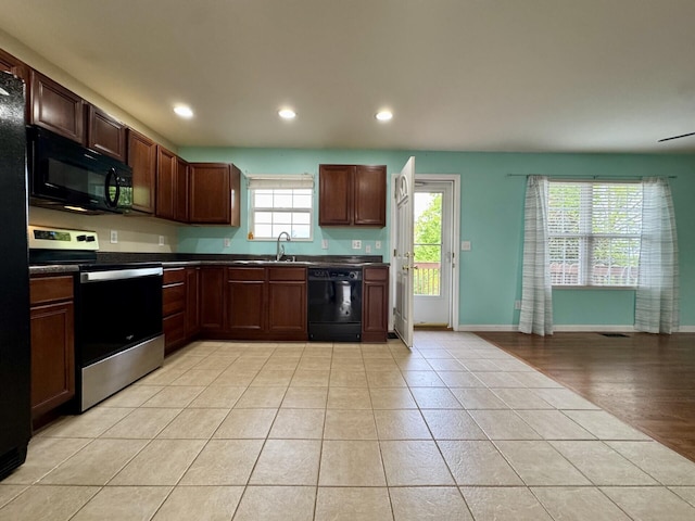 kitchen with black appliances, dark countertops, light tile patterned floors, recessed lighting, and baseboards